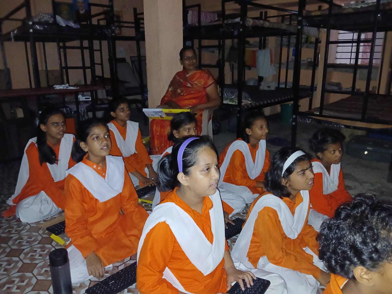 Female students receiving instruction in dormitory setting